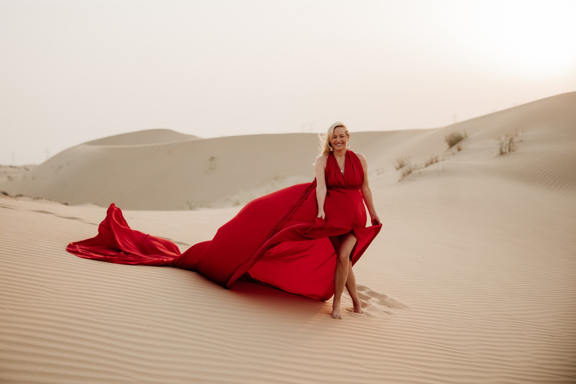 Ava Akbari im roten Kleid in den Wüstendünen